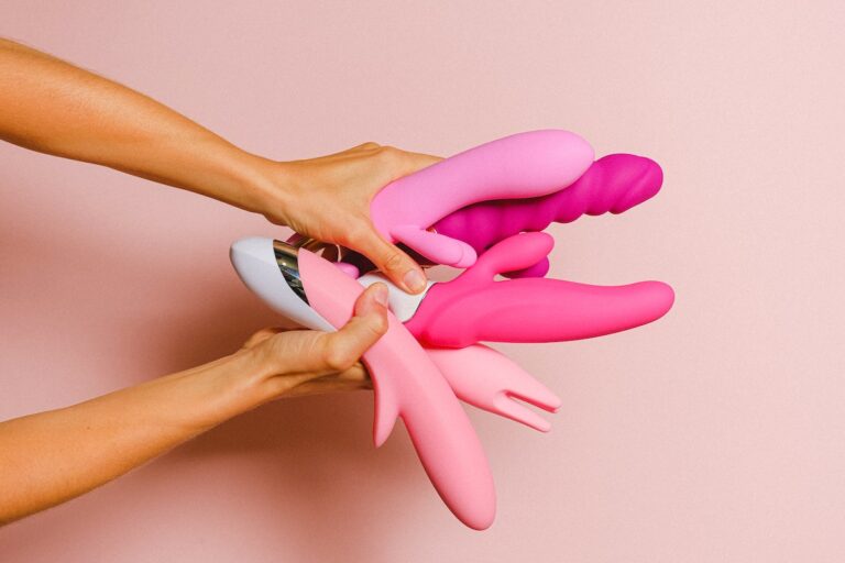Hands holding pink sex toys