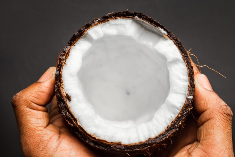 a person holding a half eaten coconut in their hands