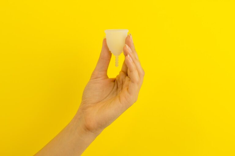 a hand holding a piece of food over a yellow background